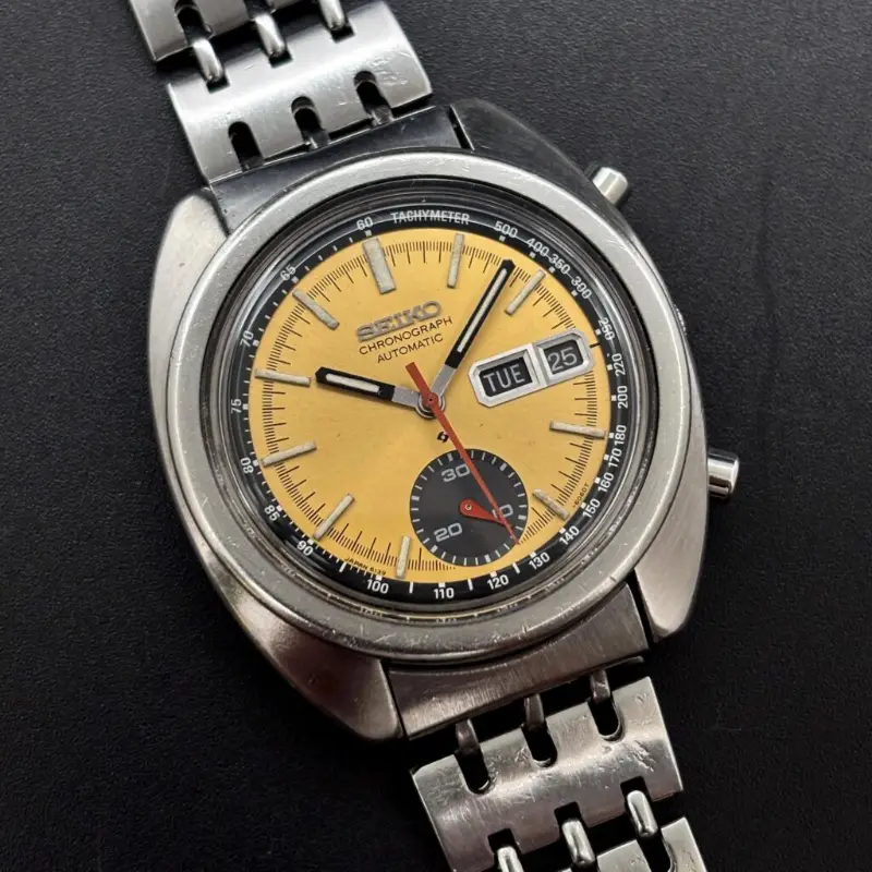 Vintage Seiko 6139-6013 automatic chronograph with a yellow dial, black tachymeter ring and day-date window on a steel bracelet
